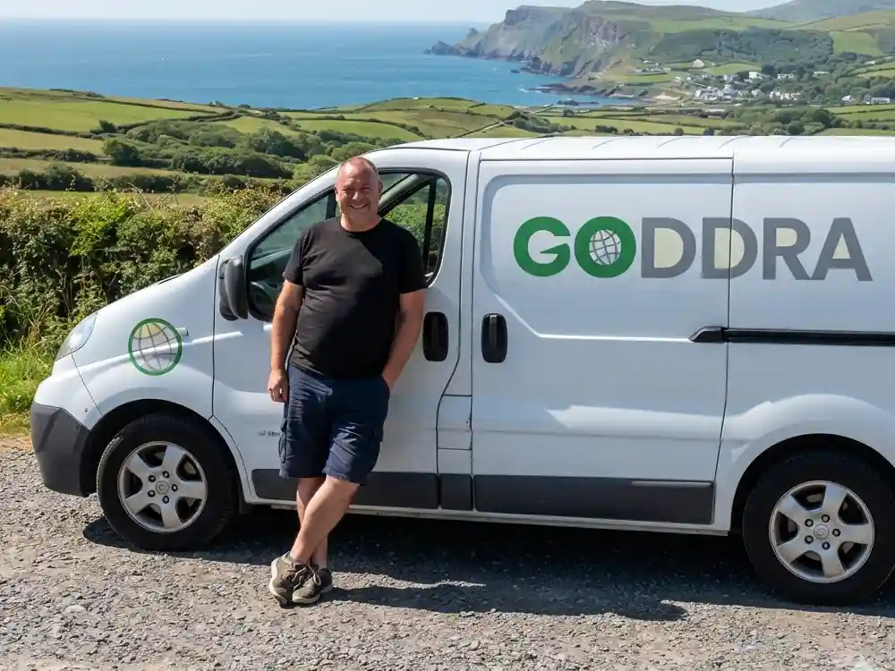 GODDRA courier driver leaning against a branded van for secure document and hardware submissions.